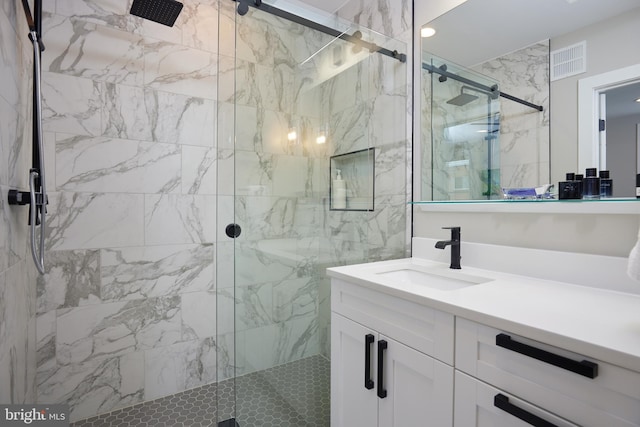 bathroom featuring vanity, visible vents, and a marble finish shower