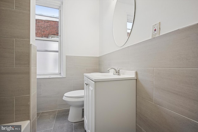 bathroom featuring toilet, tile walls, vanity, and tile patterned flooring