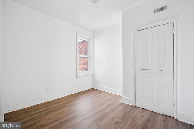 unfurnished bedroom with wood finished floors, visible vents, and baseboards