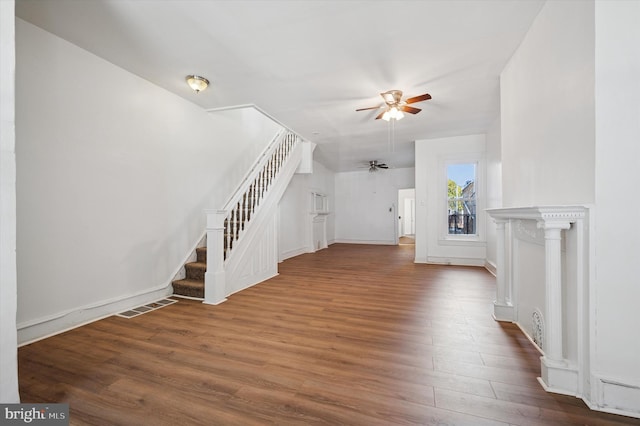 unfurnished living room featuring stairs, wood finished floors, visible vents, and ceiling fan