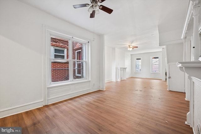 unfurnished living room featuring a ceiling fan and light wood-type flooring