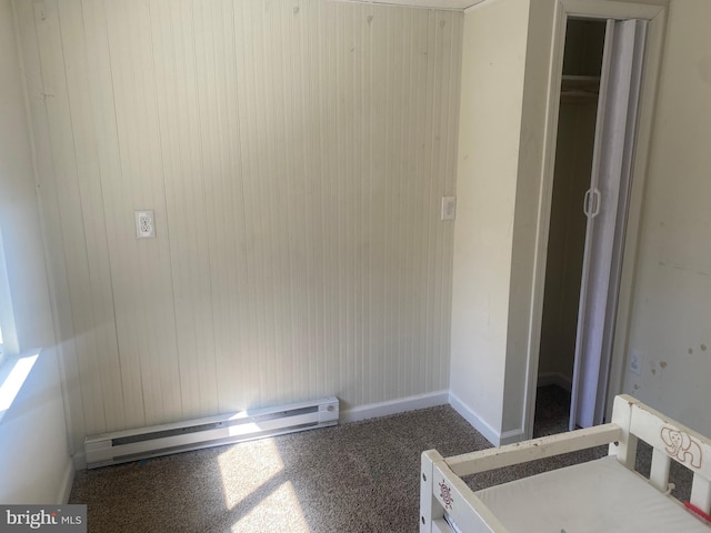 unfurnished bedroom with carpet flooring, baseboards, and a baseboard radiator