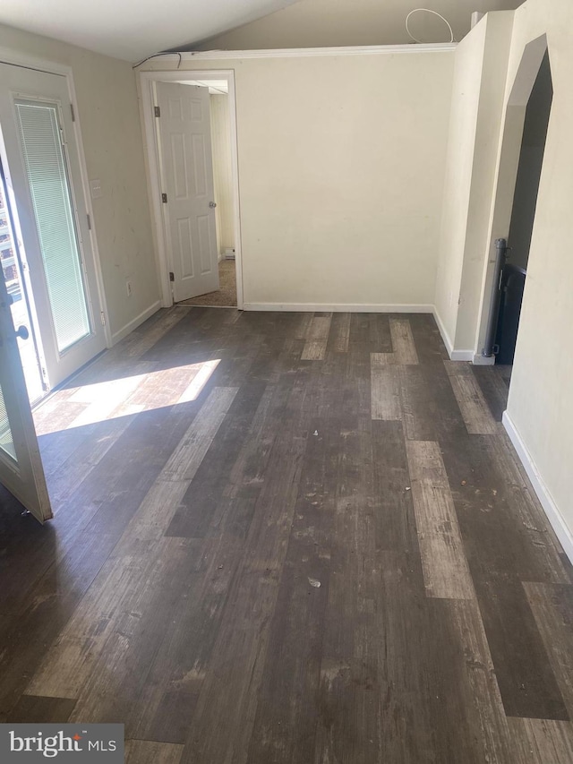 interior space featuring vaulted ceiling, baseboards, and wood finished floors