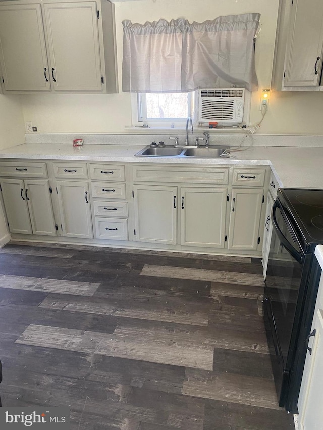 kitchen featuring light countertops, black / electric stove, dark wood-type flooring, and a sink