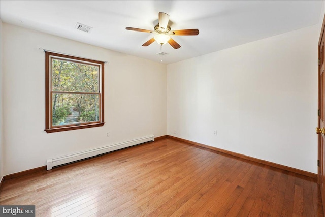 spare room with light wood finished floors, visible vents, baseboards, ceiling fan, and baseboard heating