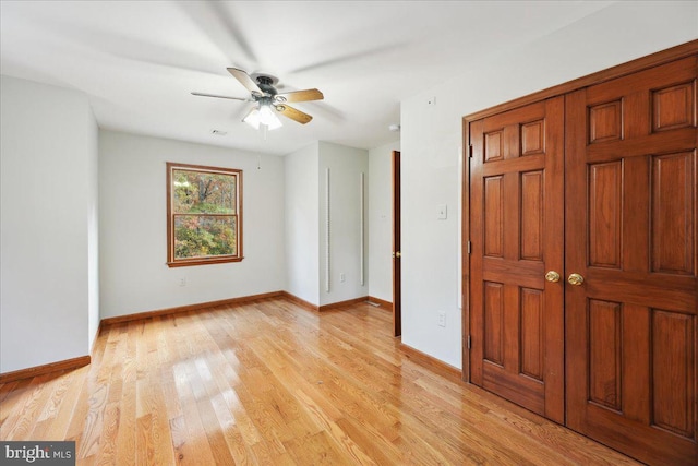 unfurnished bedroom with baseboards, light wood-style floors, and a ceiling fan