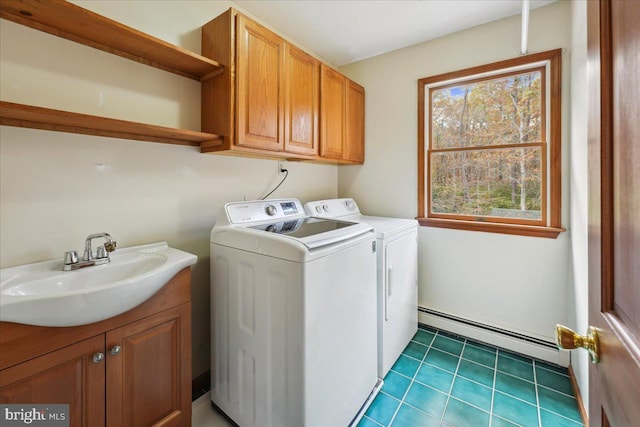 laundry area with a sink, separate washer and dryer, baseboard heating, and cabinet space