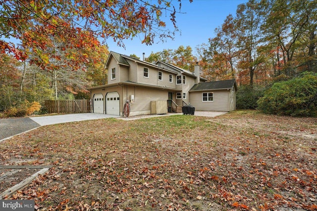 view of front of house with a chimney, driveway, and fence