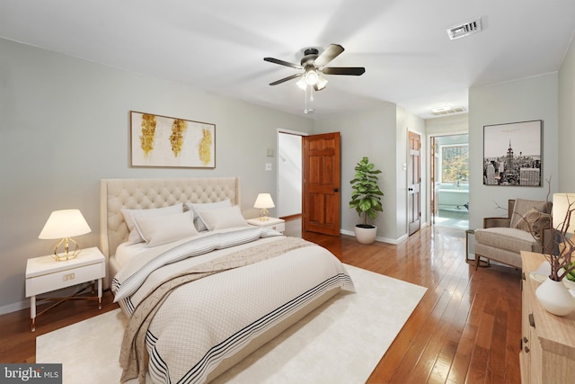 bedroom with baseboards, visible vents, ceiling fan, wood-type flooring, and connected bathroom