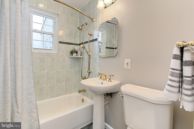 bathroom featuring a sink, toilet, and shower / tub combo