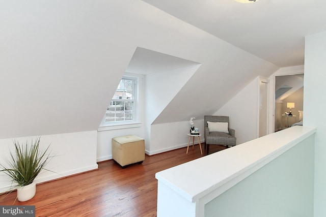 additional living space featuring vaulted ceiling, wood finished floors, and baseboards