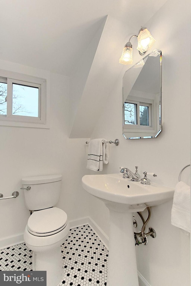 half bathroom featuring tile patterned flooring, toilet, and baseboards