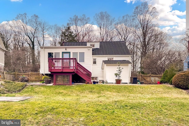 rear view of property featuring stairway, a wooden deck, a yard, and fence