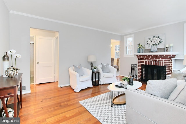 living area with light wood-type flooring, visible vents, a fireplace, crown molding, and baseboards