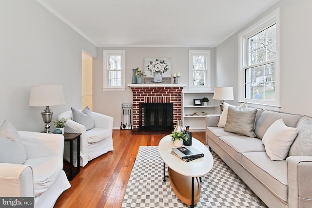 living room with a fireplace, crown molding, and hardwood / wood-style flooring