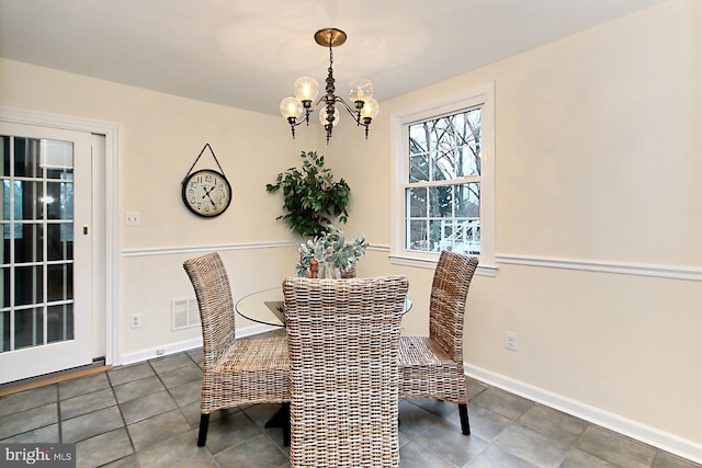 tiled dining area featuring baseboards and an inviting chandelier