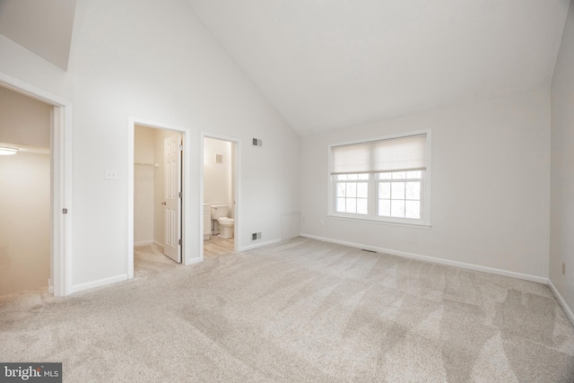 unfurnished bedroom with carpet flooring, high vaulted ceiling, and a spacious closet