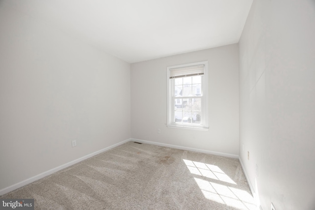 carpeted empty room with baseboards