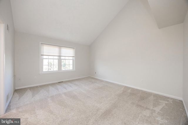 empty room featuring lofted ceiling, visible vents, baseboards, and carpet floors