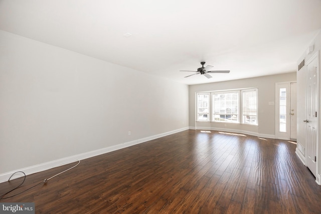 interior space with visible vents, baseboards, a ceiling fan, and dark wood-style flooring