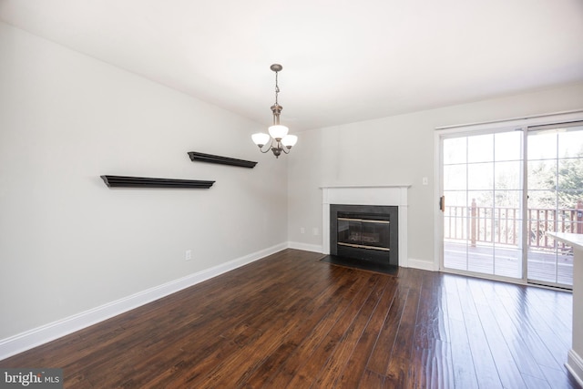 unfurnished living room featuring a chandelier, a fireplace with flush hearth, dark wood-type flooring, and baseboards