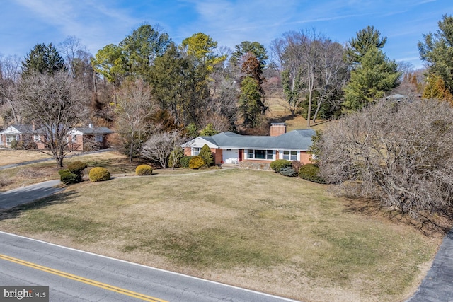 view of front of home with a chimney and a front lawn