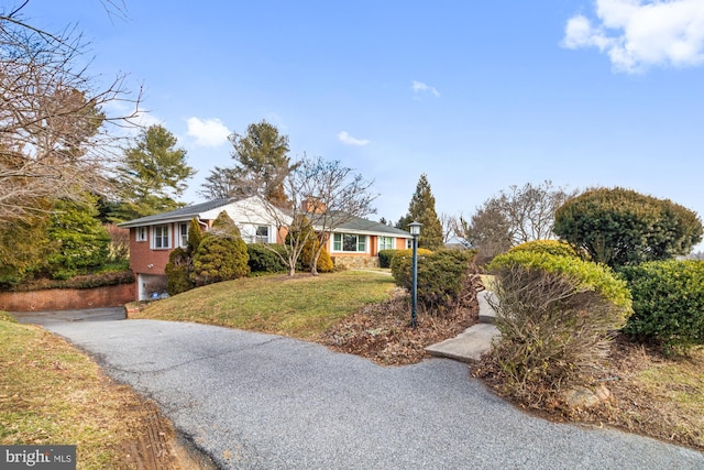 ranch-style house featuring a garage, driveway, and a front yard