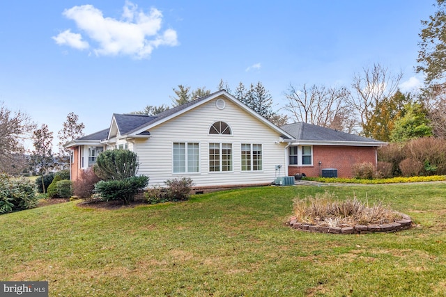 rear view of house featuring crawl space, a yard, brick siding, and central AC unit