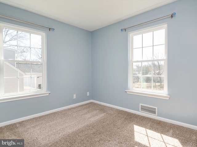 spare room featuring visible vents, carpet flooring, and baseboards