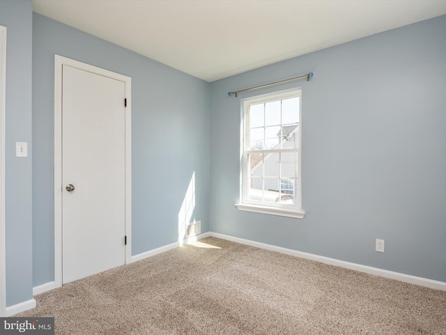 carpeted spare room with baseboards