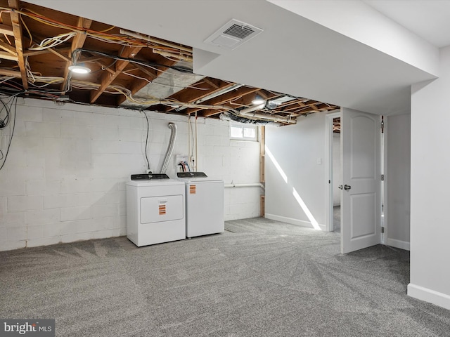 below grade area with washing machine and clothes dryer, visible vents, and carpet