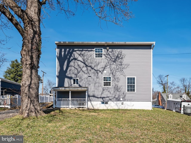 rear view of property with a lawn and fence