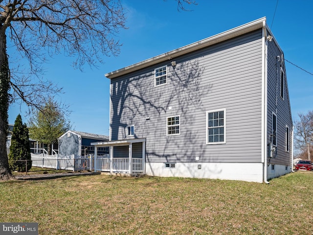 rear view of house with a lawn and fence