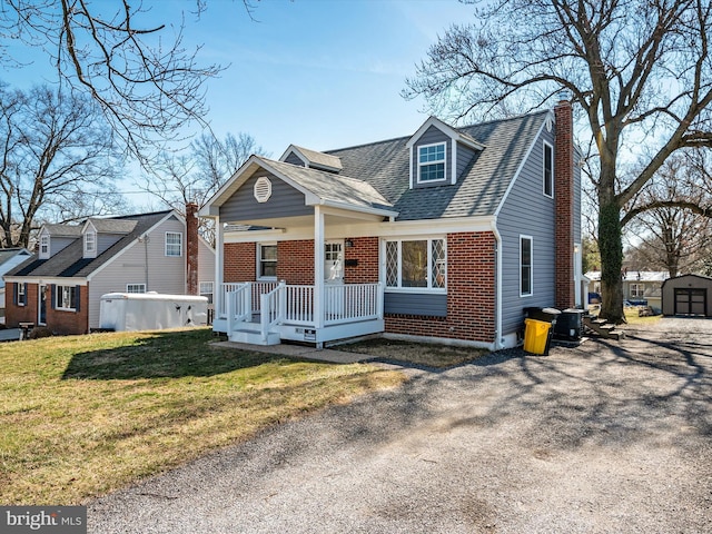 cape cod home featuring brick siding, a shed, covered porch, a chimney, and an outdoor structure