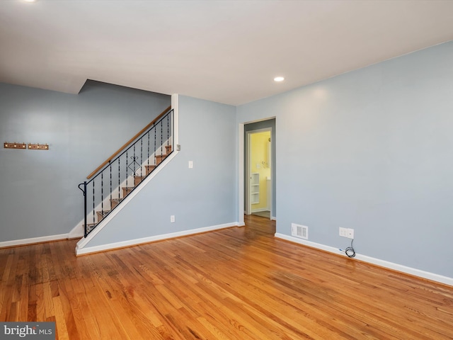 unfurnished living room featuring visible vents, baseboards, stairs, recessed lighting, and wood finished floors