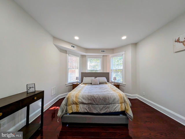 bedroom featuring wood finished floors, visible vents, and baseboards