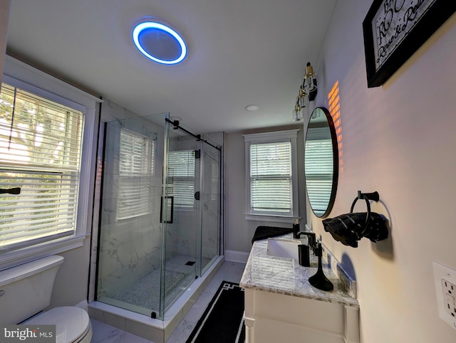 bathroom featuring vanity, toilet, baseboards, and a stall shower