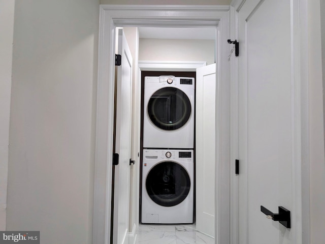 laundry room featuring laundry area, stacked washer / dryer, and marble finish floor