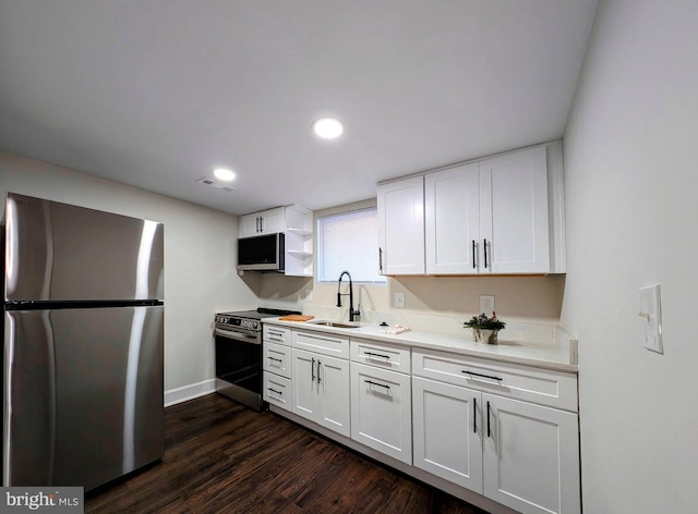 kitchen featuring visible vents, a sink, stainless steel appliances, white cabinets, and dark wood-style flooring