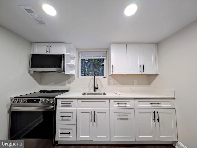 kitchen with a sink, stainless steel appliances, visible vents, and white cabinets