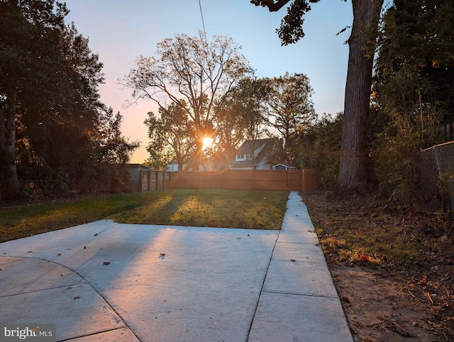 yard at dusk with a patio area and fence