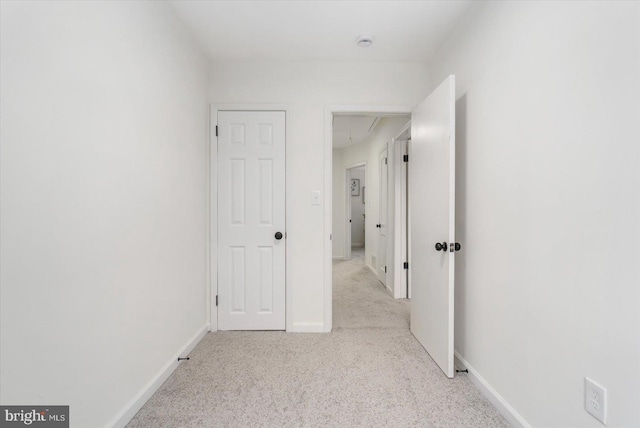 corridor featuring carpet flooring and baseboards