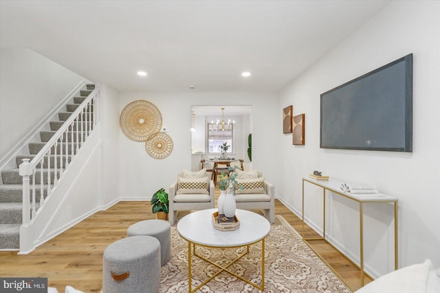 living area featuring stairway, recessed lighting, wood finished floors, and a chandelier