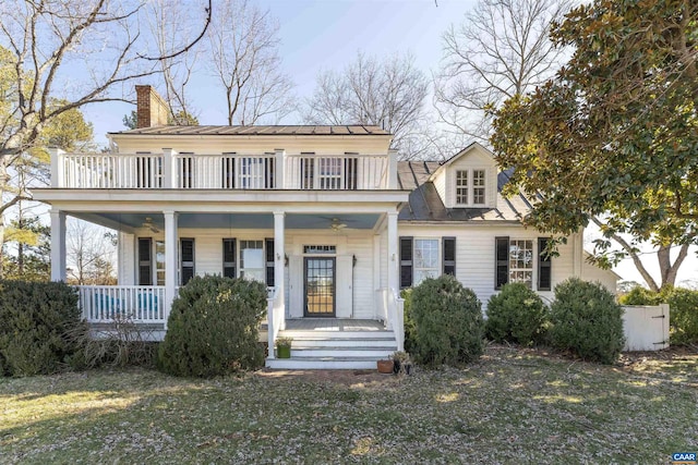 rear view of house with a porch, a chimney, and a balcony