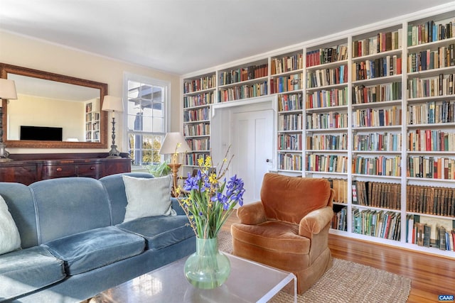 sitting room with wood finished floors and bookshelves