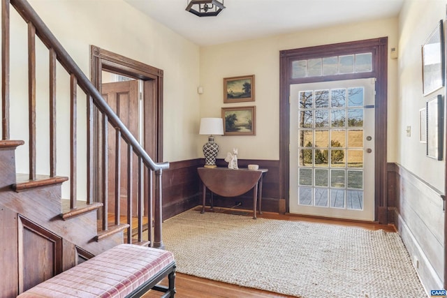 interior space with stairway, a wainscoted wall, and wood finished floors