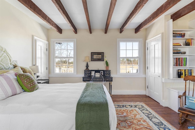 bedroom with wood finished floors, beamed ceiling, and baseboards