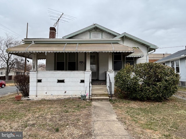 bungalow-style home with covered porch and a chimney