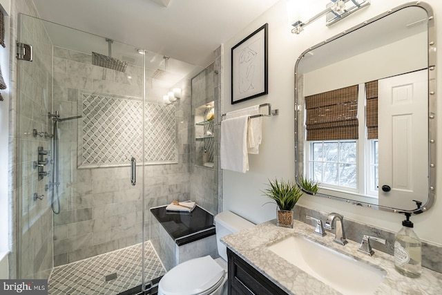 full bathroom with toilet, a shower stall, and vanity