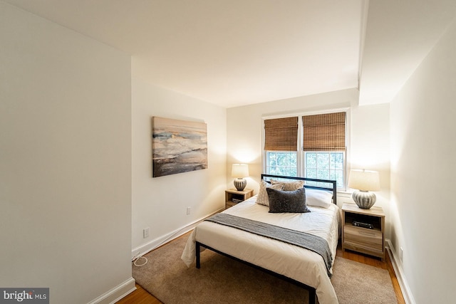 bedroom with wood finished floors and baseboards